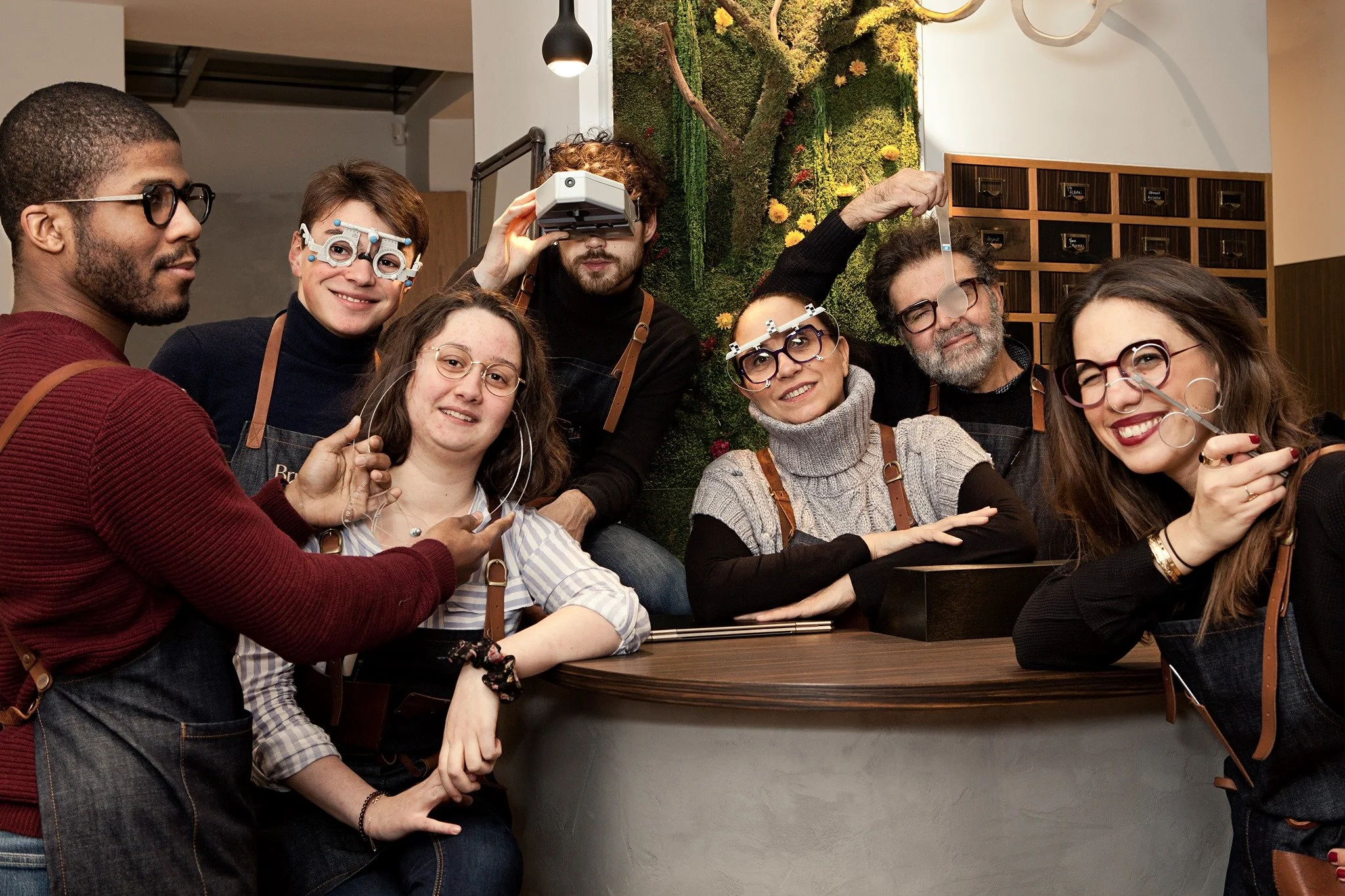 Groupe de personnes dans un café, équipées de lunettes et d’instruments optiques, faisant des expériences liées à la vision.